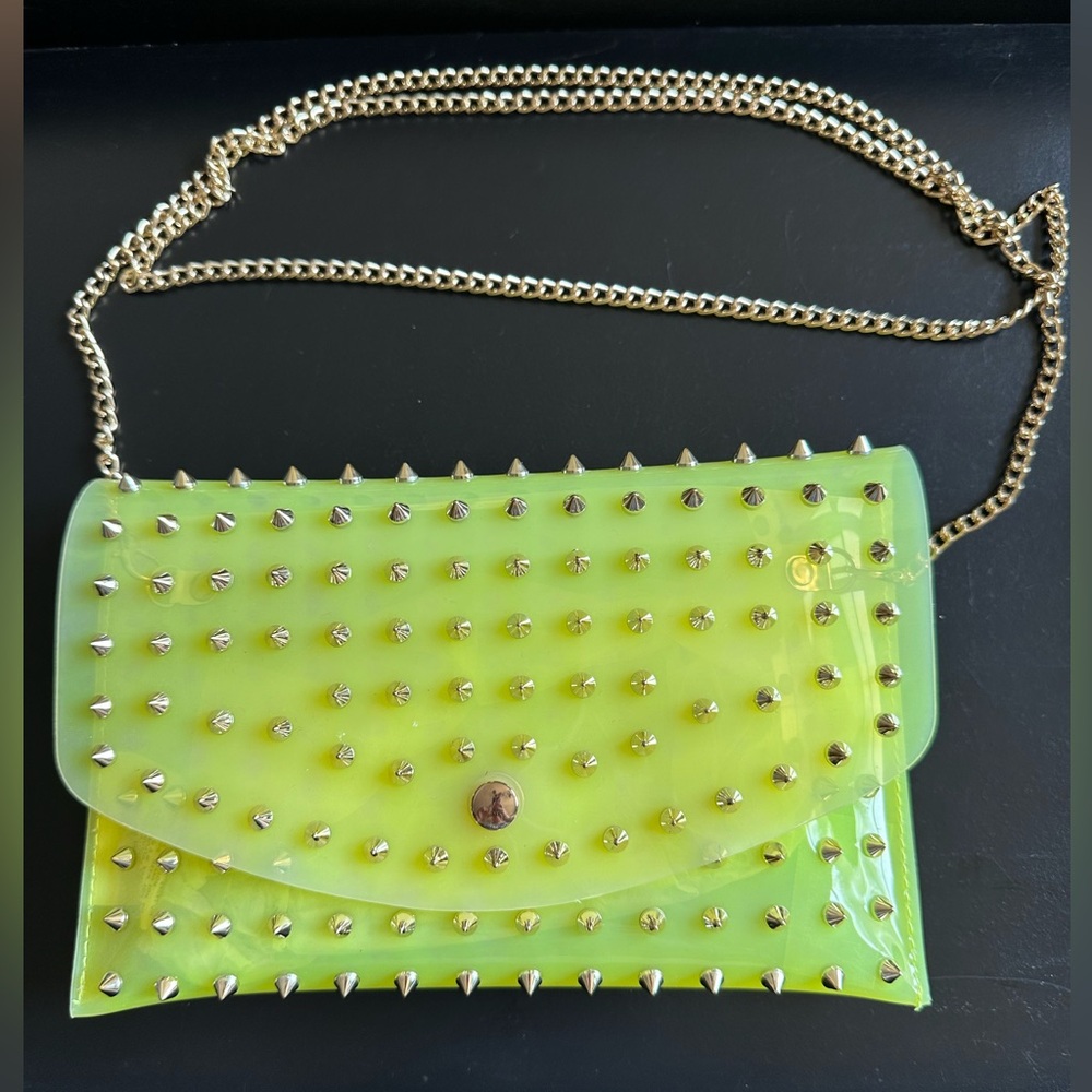 Neon yellow small crossbody jelly clutch with gold crossbody chain .
